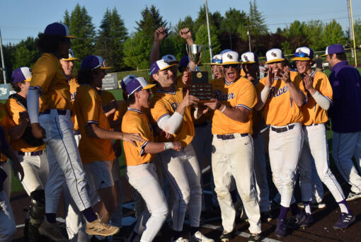 The members of the Columbia River baseball team celebrate with the district championship trophy after the Rapids' 9-2 win over W.F. West in the 4A district baseball championships at the Ridgefield Outdoor Recreation Center on Saturday, May 11, 2024.