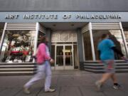 FILE - People walk past the Art Institute of Philadelphia operated by the Education Management Corporation on Nov. 16, 2015, in Philadelphia. The Biden administration on Wednesday said it will cancel $6 billion in student loans for people who attended the Art Institutes, a system of for-profit colleges that closed the last of its campuses in 2023 amid accusations of fraud.