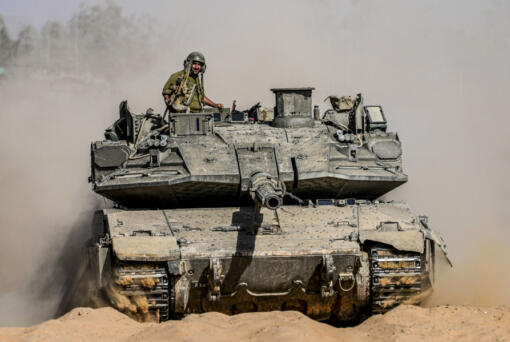 Israeli soldiers drive a tank at a staging ground near the border with the Gaza Strip, in southern Israel, Sunday, May 5, 2024.