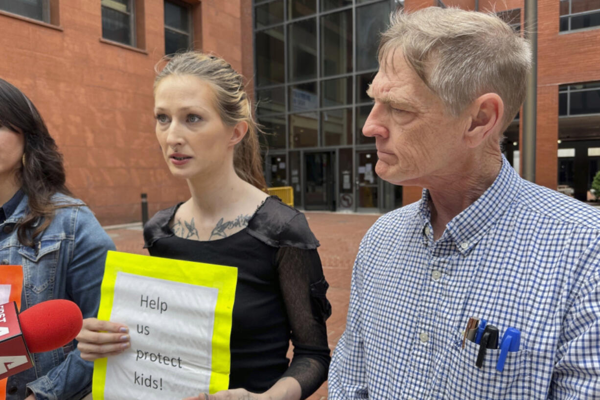 Amanda Householder, center, speaks outside the St. Louis office of Missouri Attorney General Andrew Bailey on Monday, May 13, 2024, as David Clohessy, right, listens. They were among a group of people urging Bailey to take action in response to allegations of child abuse at Christian boarding schools in southern Missouri.
