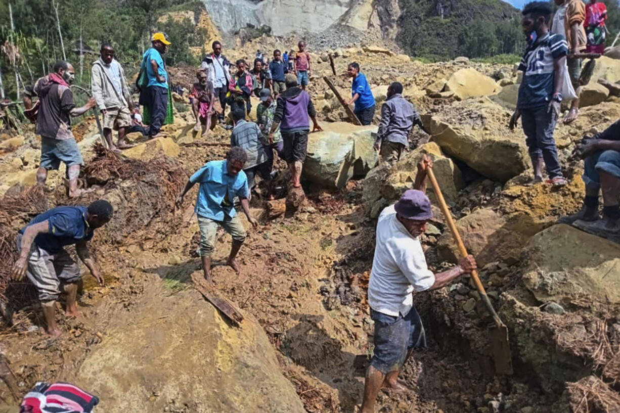 Villagers search through a landslide in Yambali, in the Highlands of Papua New Guinea, Sunday, May 26, 2024. The International Organization for Migration feared Sunday the death toll from a massive landslide is much worse than what authorities initially estimated.