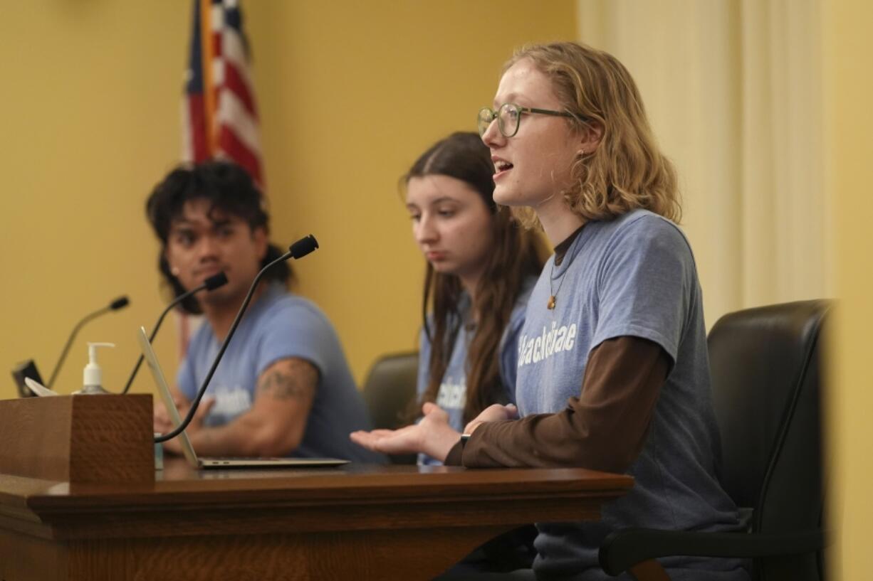 Libby Kramer, of Climate Generation, right, speaks to the Minnesota Youth Council, Tuesday, Feb. 27, 2024, in St. Paul, Minn. The advocates called on the council, a liaison between young people and state lawmakers, to support a bill requiring schools to teach more about climate change.