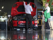 A salesperson shows an unsold 2024 Cooper SE electric hardtop to a prospective buyer at a Mini dealership Wednesday, May 1, 2024, in Highlands Ranch, Colo. On Friday, May 3, 2024, the U.S. government issues its April jobs report.