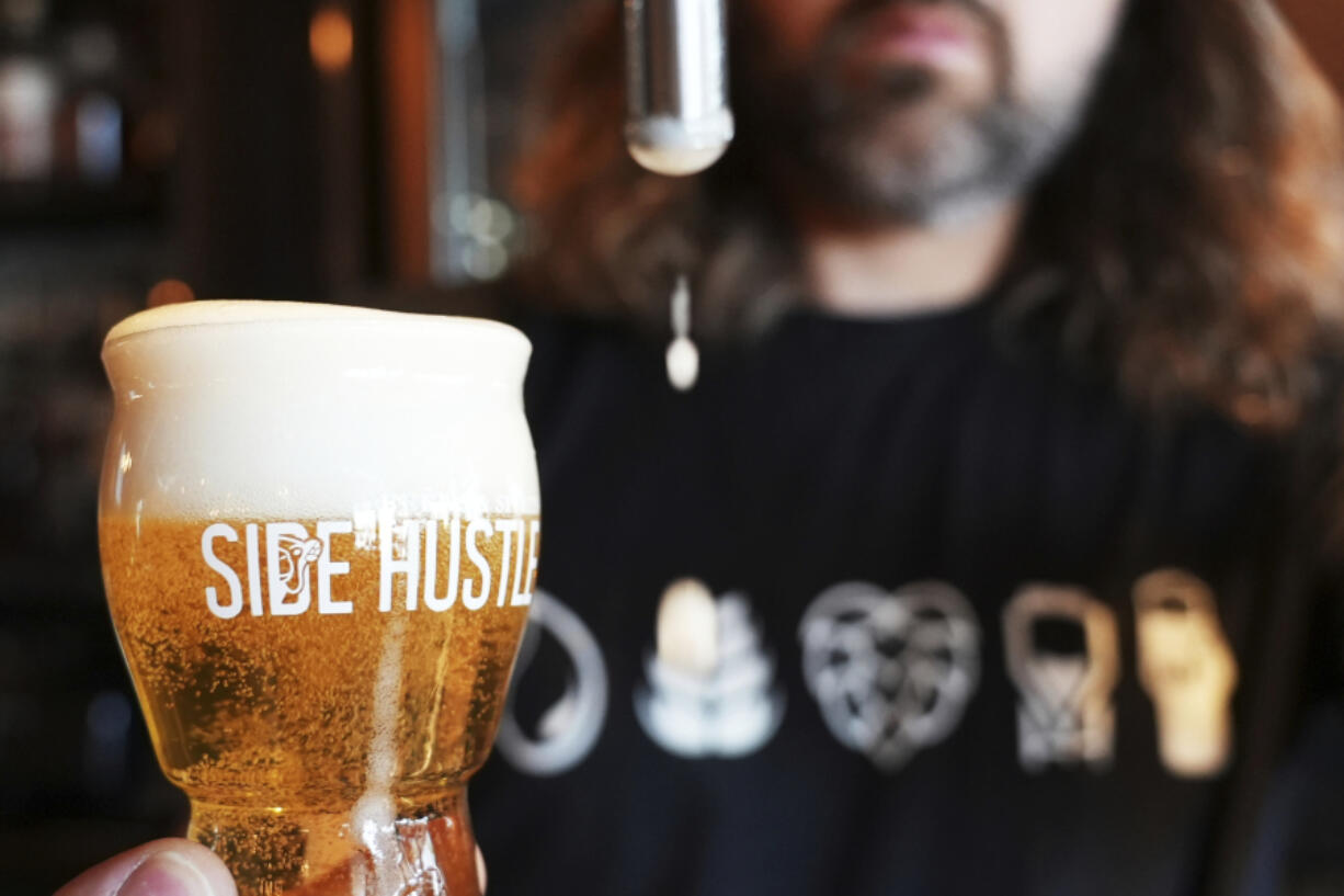 Mitchell Dougherty, the brewmaster at Side Hustle Brews and Spirts, pours a pint of beer May 13 at their brewpub in Abu Dhabi, United Arab Emirates.