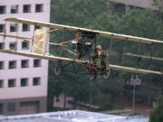 Aviator Tom Murphy pilots his Curtis Pusher biplane replica through downtown Portland on Sept. 16, 1995, after flying  off a ramp on top of the eight-story tall historic Multnomah Hotel in a re-enactment of a 1912 flight to Vancouver.