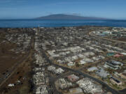 FILE - A general view shows the aftermath of a wildfire in Lahaina, Hawaii, Thursday, Aug. 17, 2023. Maui County is suing major cellular carriers for failing to properly inform police of widespread service outages during the height of last summer&rsquo;s deadly wildfire. (AP Photo/Jae C.