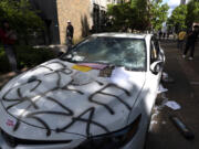 A car that attempted to drive through a crowd of pro-Palestinian protesters on the Portland State University campus is seen parked and damaged on a campus walkway on Thursday, May 2, 2024, in Portland, Ore. After the driver fled on foot the protesters damaged the car.