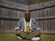 Lama Rod Owens sits in the yard of his childhood home March 30 in Rome, Ga. Owens is an influential voice in a new generation of Buddhist teachers, respected for his work focused on social change, identity and spiritual wellness.