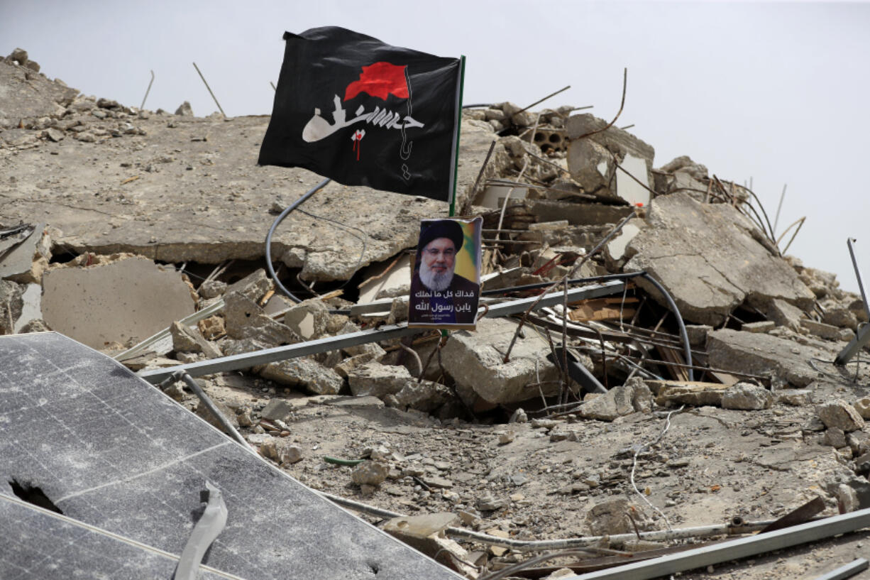 A picture of Hezbollah leader Sayyed Hassan Nasrallah sits on a house previously destroyed in an Israeli strike, in Aita al-Shaab village, south Lebanon, Monday, May 27, 2024.