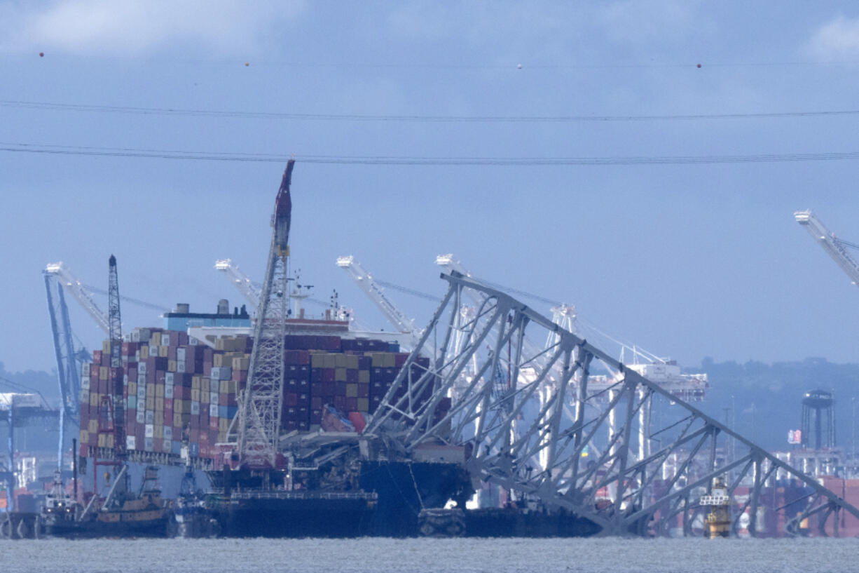 The collapsed Francis Scott Key Bridge rests on the container ship Dali, Sunday, May 12, 2024, in Baltimore, as seen from Riviera Beach, Md. An effort to remove sections of the collapsed bridge resting on the Dali was postponed on Sunday.