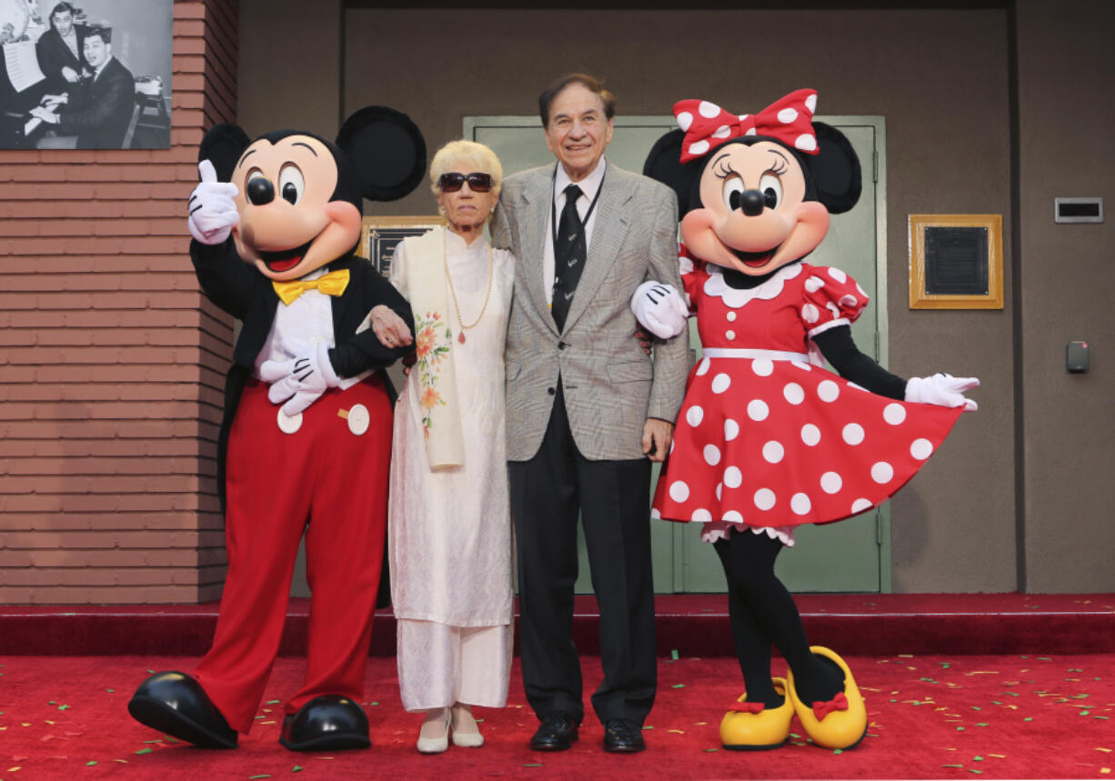FILE - Mickey Mouse, from left, Elizabeth Gluck, Richard M. Sherman and Minnie Mouse pose for a photo at the ceremony honoring the Sherman Brothers with the rename of Disney Studios Soundstage A at the world premiere of Disney&#039;s &quot;Christopher Robin&quot; at the Walt Disney Studios, July 30, 2018, in Burbank, Calif. Sherman, one half of the prolific, award-winning pair of brothers who helped form millions of childhoods by penning classic Disney tunes, died Saturday, May 25, 2024. He was 95.