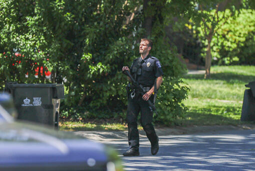 A Charlotte Mecklenburg police officer carries a gun as he walks in the neighborhood where an officer-involved shooting took place in Charlotte, N.C., Monday, April 29, 2024. Police in North Carolina say numerous law enforcement officers conducting a task force operation have been struck by gunfire in Charlotte.