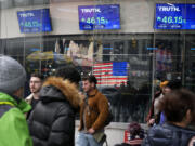 FILE - Pedestrians walk past the Nasdaq building as the stock price of Trump Media &amp; Technology Group Corp. is displayed on screens, March 26, 2024, in New York. A Delaware judge on Tuesday, April 30, granted a request by attorneys for Donald Trump and Trump Media &amp; Technology Group, parent company of his Truth Social platform, to slow down a lawsuit filed by two cofounders of the company.
