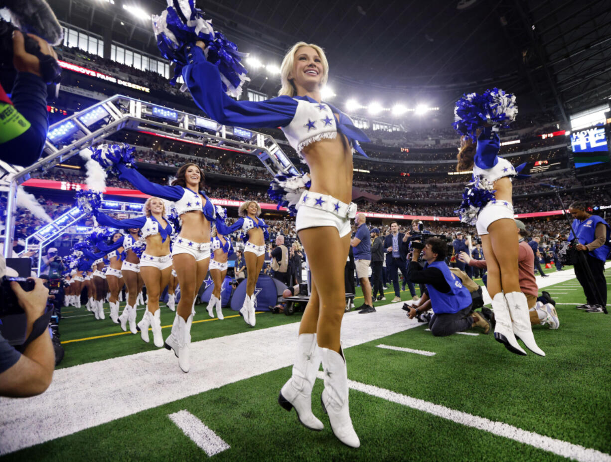 The Dallas Cowboys Cheerleaders skip onto the field during their introduction before a game against the Washington Commanders at AT&amp;T Stadium in Arlington, Texas, on Nov. 23, 2023.