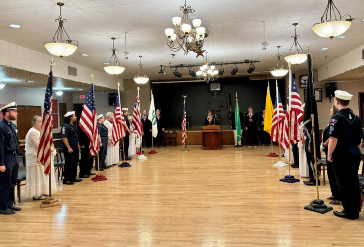 Sea Scouts and Emblem Club members observe while the exalted ruler of the Elks calls the lodge to attention to recite the Pledge of Allegiance.