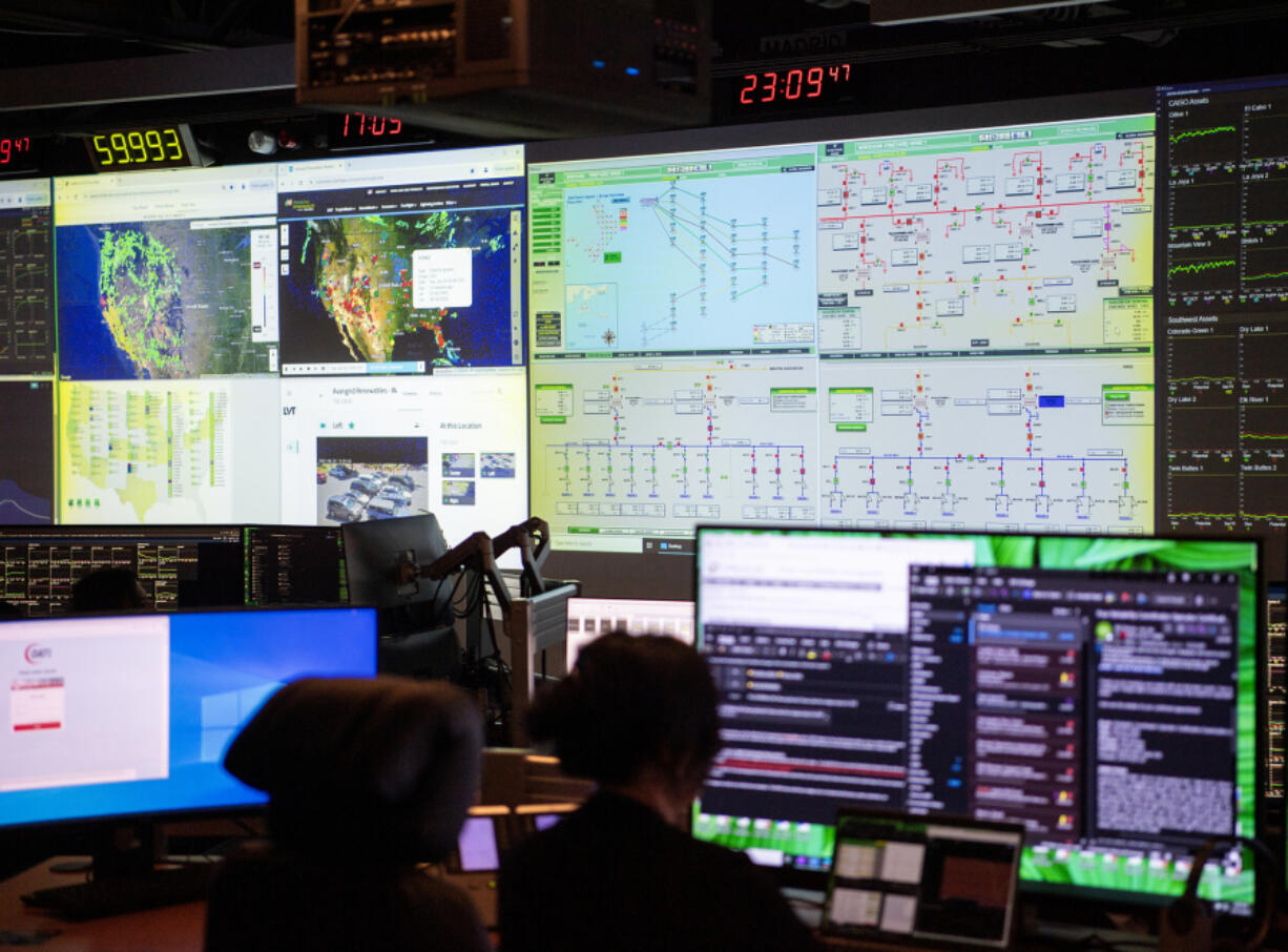 Workers monitor electricity production at Avangrid's green energy sites across the country Tuesday from the company's National Control Center in Vancouver. The company produces energy for millions of homes across the country.