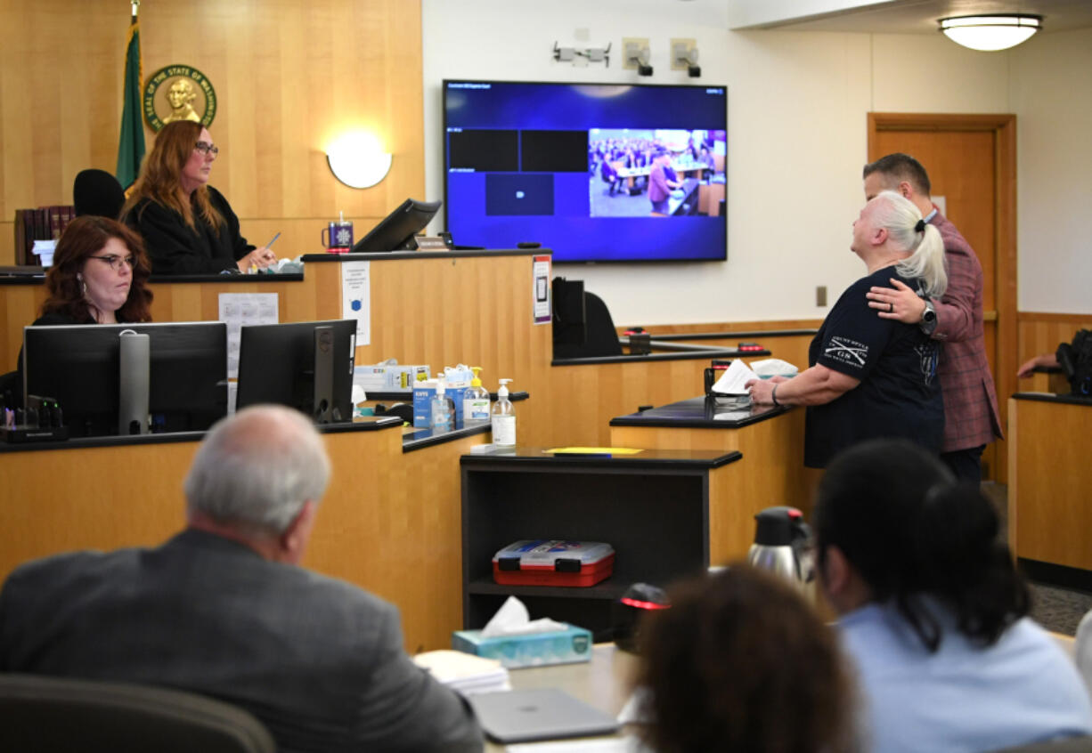 Clark County Superior Court Judge Nancy Retsinas, second from left, listens to a victim impact statement from Darlene Baun, right, the mother of fallen Vancouver police Officer Donald Sahota during a Thursday sentencing hearing for Julio Segura, bottom right in foreground. Segura was found guilty of murder in the 2022 death of Sahota.