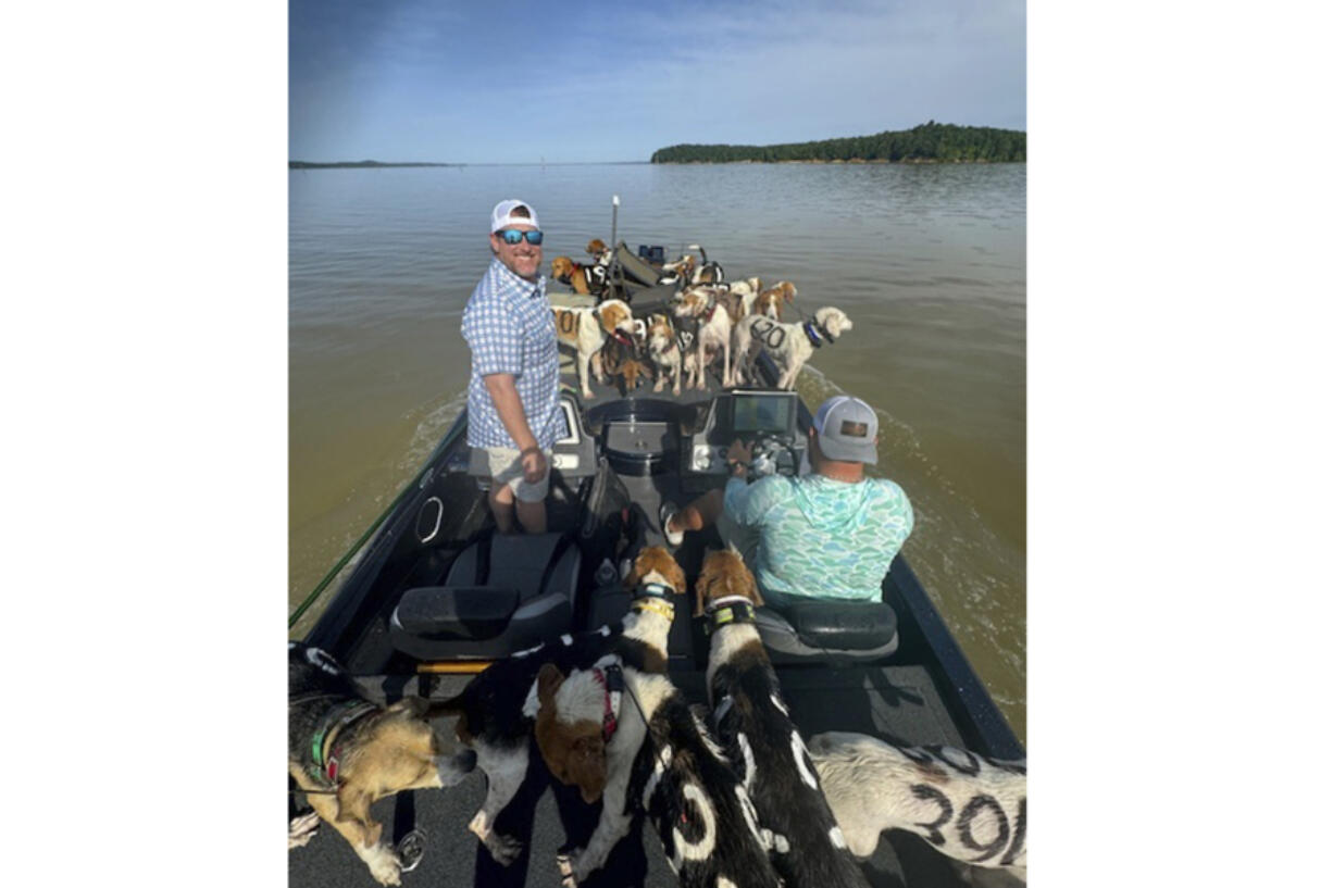 Fisherman Brad Carlisle, left, and fishing guide Jordan Chrestman bring one of three boatloads of dogs back to shore after they were found struggling to stay above water far out in Mississippi&rsquo;s Grenada Lake.