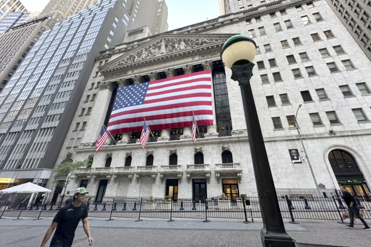 File - People pass the New York Stock Exchange on May 28, 2024, in New York. Global shares have advanced on Friday, June 28, 2024, as traders look ahead to a key report on inflation that could influence the Federal Reserve&rsquo;s next move on interest rates.