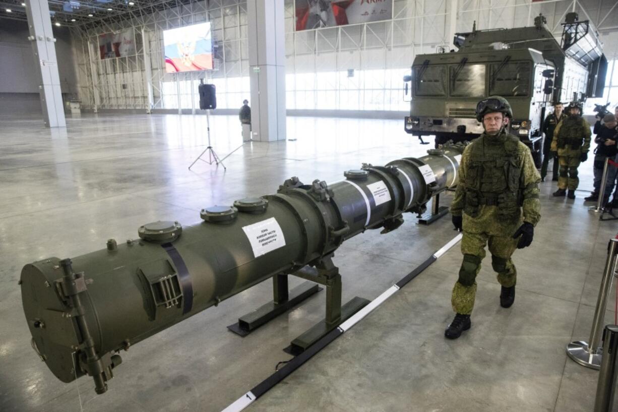 FILE - A Russian military officer walks past the 9M729 land-based cruise missile on display in Kubinka outside Moscow, Russia, on  Jan. 23, 2019. Russian President Vladimir Putin has called for resuming production of intermediate-range missiles that were banned under a now-scrapped treaty with the US. The Intermediate-Range Nuclear Forces treaty, which banned ground-based missiles with a range of 500-5,500 kilometers (310-3,410 miles) was regarded as an arms control landmark when Soviet leader Mikhail Gorbachev and U.S. President Ronald Reagan signed it in 1988.