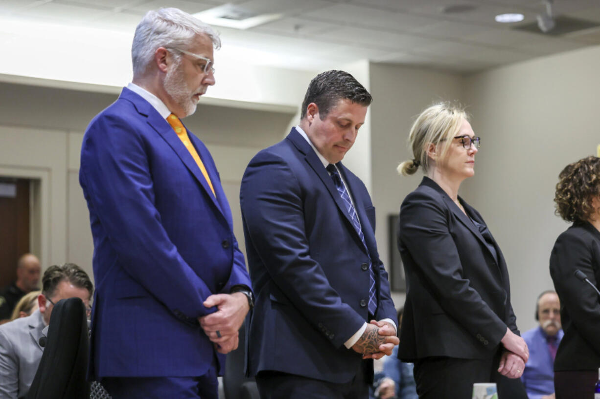 Jeffrey Nelson, flanked by attorneys, stands at the King County Maleng Regional Justice Center in Kent, Wash., on Thursday, June 27, 2024. A jury found the suburban Seattle police officer guilty of murder in the 2019 shooting death of a homeless man outside a convenience store, marking the first conviction under a Washington state law easing prosecution of law enforcement officers for on-duty killings.