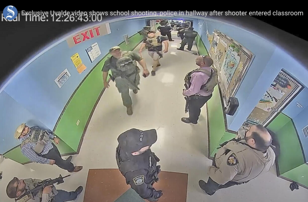 FILE - In this photo from surveillance video provided by the Uvalde Consolidated Independent School District via the Austin American-Statesman, authorities stage in a hallway as they respond to the shooting at Robb Elementary School in Uvalde, Texas, May 24, 2022. The former Uvalde schools police chief and another former officer have been indicted over their role in the slow police response to the 2022 massacre in a Texas elementary school that left 19 children and two teachers dead, according to multiple reports Thursday, June 27, 2024.